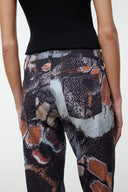 High-rise flare jeans with abstract butterfly print in dark, gray, and orange tones