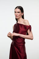 Deep burgundy silk midi dress with off-shoulder neckline and gathered bow at shoulder