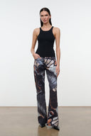 Straight-to-flare jeans with abstract butterfly print, dark base, gray panels, orange accents