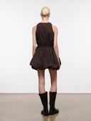 Back view of dark brown sleeveless mini dress with gathered waist and flared skirt