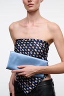Light blue satin clutch bag with fold-over top, held in hand