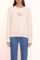 Light pink crewneck sweatshirt with long sleeves and small chest graphic