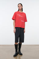 Relaxed red T-shirt with crew neck and front graphic print, worn with dark bottoms