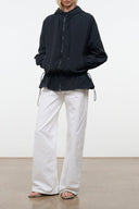 Black hooded wind jacket with front zipper, drawstring hem, and long balloon sleeves