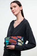Small convertible shoulder bag held in hand, butterfly sequin pattern with black strap