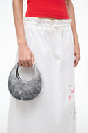 Silver crescent bag on model with black interior and top snap