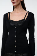Black cashmere sweater close-up: square neckline, strap trim, metal-button placket