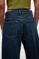 Relaxed-fit dark blue jeans with back yoke and two patch pockets.