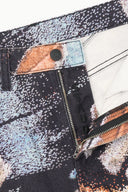 Abstract-print jeans with zip fly and orange pocket accents, black and white speckled