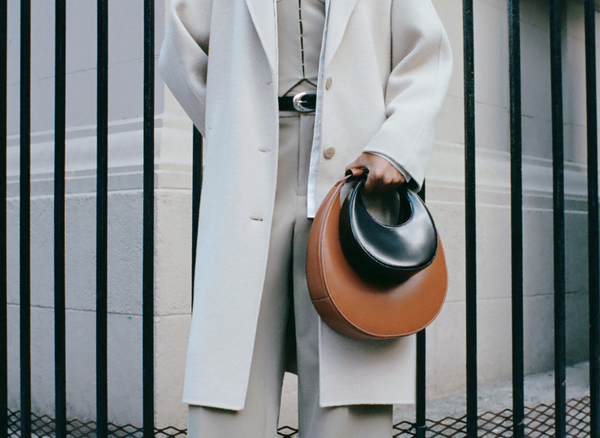 a woman holding two handbags 