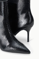 Black snake-print ankle boot close-up, curved stiletto heel