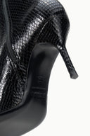 Black snake-print ankle boot close-up of side zipper and pointed toe