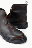 Espresso distressed zip ankle boot close-up, brown welt stitching and tread sole