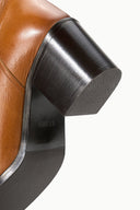 Cashew brown tall boot with black rounded block heel and side panel
