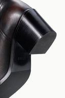 Close-up of dark leather boot heel and tread sole with padded edge