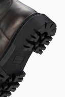 Chunky black lug boot sole with tread pattern and embossed logo detail