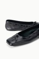Pair of black leather flat ballet shoes, close-up of bow and lacing
