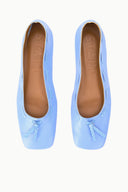 Light blue flat ballet shoes showing interior and tan lining with bow at toe