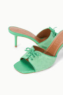 Seafoam suede mules with open toe and lace-up bow, shown from angled front view