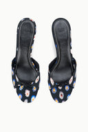 Pair of black floral mules with low kitten heel, slip-on style and patterned toe