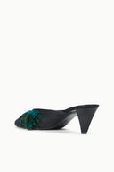 Black mule with teal feather trim across the toe, side angle showing low heel