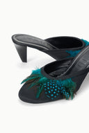 Black VELA mule close-up: teal feather trim and textured insole, low heel