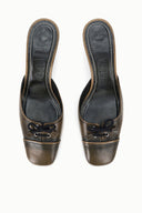 Pair of black distressed mules with pointed toe, lace-up front, and covered stiletto heel