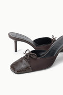 Pair of espresso mules with lace-up front, snake-texture toe, and stiletto heels.
