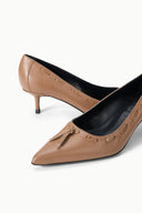 Tan pointed-toe kitten heel pumps with tassel bow and leather upper detail