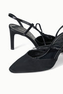 Black heeled slingback sandal close-up with bow ankle ties and strap details