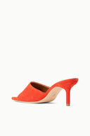 Orange suede backless mule with open toe and slim stiletto heel, angled side view.