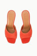 Orange suede open-toe mule sandals with cushioned footbed and slim stiletto heel.