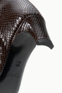 Close-up of dark espresso brown snake-embossed boot upper and heel sole detail.