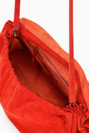 Interior view of tangerine-orange oversized suede bag with zipper pocket and lining.