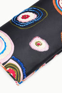 Close-up of black clutch with multicolor paisley patches and beaded trim accents.