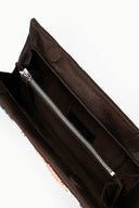 Black clutch bag open, showing black interior and silver zipper detail