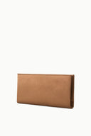 Tan leather clutch bag angled view with curved flap edge and slim profile.