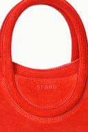 Maude mini tote bag close-up in tangelo red, STAUD logo on front pocket