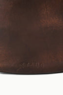 Distressed espresso brown leather hobo bag close-up of bottom edge texture