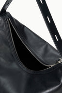 Black hobo bag close-up: double zippers at open top and textured finish