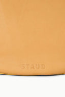 Cashew tan hobo bag with embossed "STAUD" logo at bottom edge