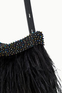 Close-up of black feather fringe with colorful jeweled bead trim
