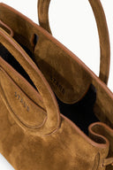 Cigar-brown mini carryall interior with tan lining pocket and STAUD branding.