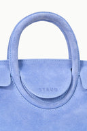 Light blue mini carryall handbag close-up: top handle with embossed logo tab