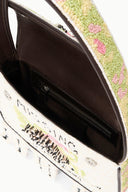 Beaded mini bag interior with black pocket and zipper, showing cream printed side