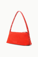 Red-orange shoulder bag with top handle, side detail, and logo on front