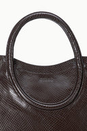 Espresso snake-embossed satchel close-up of curved handle and stitched trim