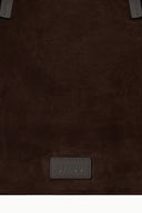 Brown suede tote front with stitched leather logo patch