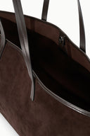 Brown suede tote interior view with lined space, pocket, and side hardware