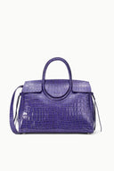 Purple croc-embossed carryall with rolled top handles and side tassel ties
